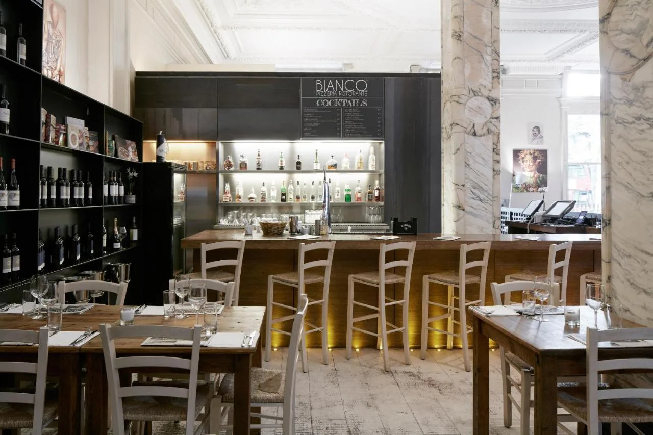 a restaurant with tables and chairs and a bar at The Grand at Trafalgar Square in London