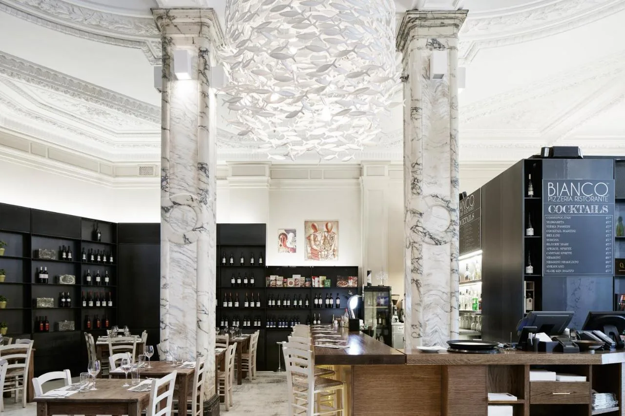 a dining room with columns and tables and chairs at The Grand at Trafalgar Square in London